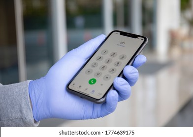 Alanya, Turkey - March 24, 2020: Man Hand In Disposable Protective Glove Holding IPhone 11 With Call Number Sos On The Screen.