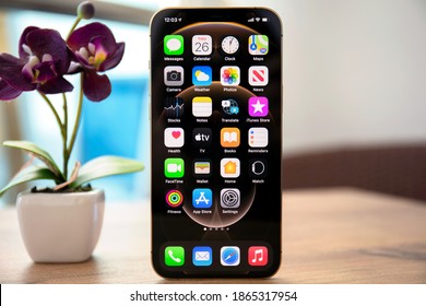 Alanya, Turkey - November 26, 2020: iPhone 12 Pro Max Gold with home screen IOS 14 on the screen on the table. iPhone 12 Pro Max Gold was created and developed by the Apple inc.
