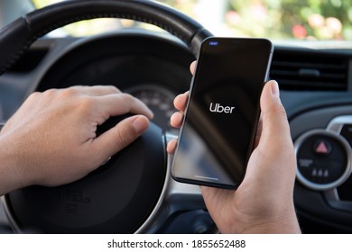 Alanya, Turkey - October 5, 2020: Man hands holding Apple iPhone 11 with application Taxi Uber in the screen. iPhone 11 was created and developed by the Apple inc.