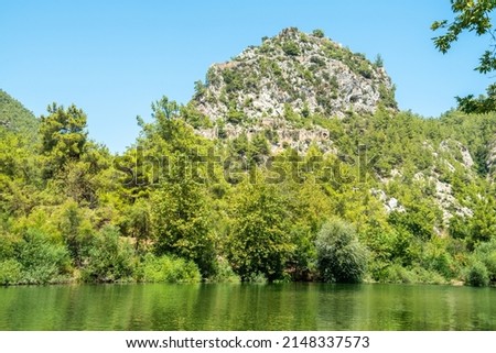 Alara River and a massive rocky hill with the ruins of Alara Castle in Alanya, Turkey. The castle dates from the 13th century.