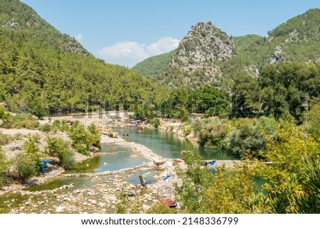 Alara (Uluguney) River running among mountains near Alanya, Turkey. View with basic picnic facilities and people, in summer.