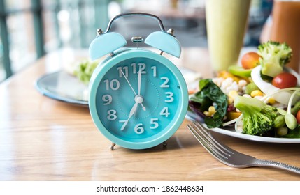 Alarm clock of blue  which schedule of meal for weight loss and Intermittent fasting concept - Shutterstock ID 1862448634