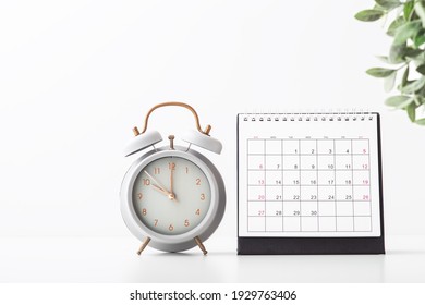 Alarm clock and calendar on white background with copy space