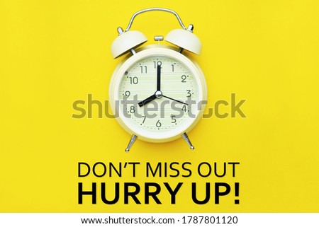 Alarm clock and Don't miss out hurry up text on yellow background.