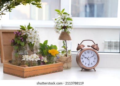 Alarm Clock With Flowering Branches In A Wooden Box On The Windowsill. Spring Forward.