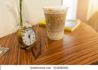 Alarm Clock With Iced Coffee On Table At Cafe