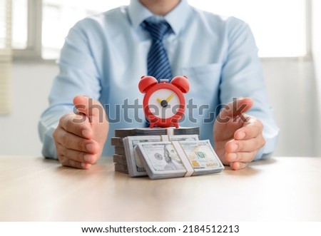 Alarm clock and money in businessman's hands, money and time management, Reminder of payment deadline, pay bill, quick loan and finance debt concept.