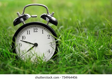 Black Alarm Clock On Grass Background Stock Photo (Edit Now) 1062191432