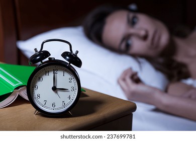 Alarm clock on night table showing 3 a.m.
