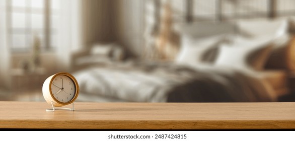 ALarm clock on wooden table top in a nice cozy and bright bedroom. Blurred bed and window background. Copy space for products display.