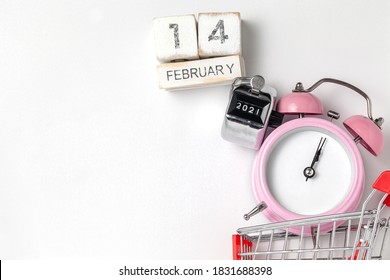 alarm clock in a pink plastic case and black hands in a metal shopping cart with tally click counter  on a white background selective focus isolated