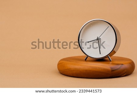 Alarm clock placed on a wooden stand, time work concept the value of limited time Appointments and punctuality at work