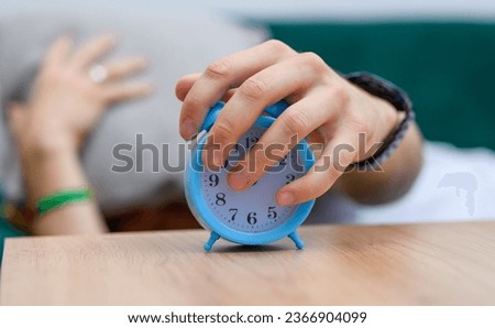 The alarm clock ringing next to the bed in the middle of the night