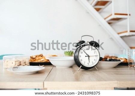 Alarm clock showing iftar time on wooden table