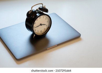 Alarm clock standing on laptop. Concept of work hours, deadline and limit screen time. - Shutterstock ID 2107291664