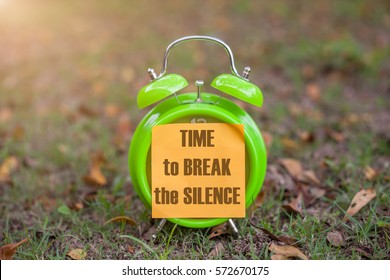 Alarm Clock With Sticky Paper Written  TIME TO BREAK THE SILENCE Over Blur Background