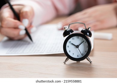 Alarm Clock For A Student Writing Exams, Taking An Exam Room With A Pencil Holding On An Optical Form Of A Standardized Test With Answers 