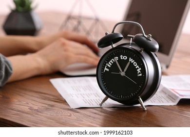 Alarm clock with text TIME TO WORK on office table