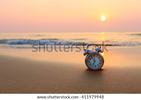 Alarm clock vintage with sunrise on beach
