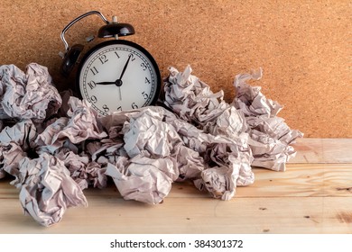 Alarm clock in a wastepaper  concept for a time waste of time with cork board texture background