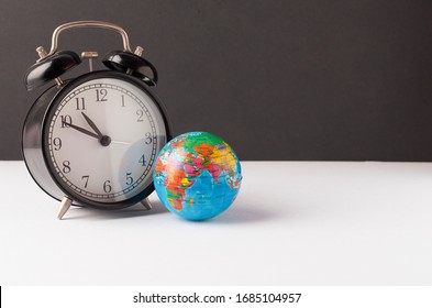 Alarm clock with world globe. World time concept. Selective focus.