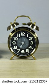 alarm o'clock showing 7 o'clock on wood table 