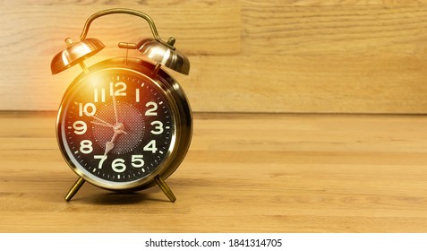 alarm showing 7 o' Clock on wood table