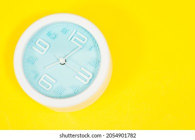 alarm showing 7 o' Clock on yellow background