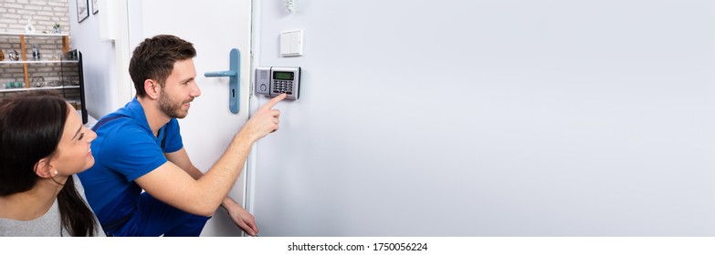 Alarm System Security Installation At Home. Technician Installing Near Door