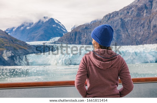 Alaska\
cruise inside passage to Glacier bay National Park woman tourist\
relaxing on deck watching landscape nature background in spring\
with melting ice. Scenic cruise vacation\
trave.
