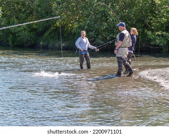 Alaska USA August 11 2008; Young Women Side Of Alaskan River In Waders Salmon Fishing With Fishing Guide.