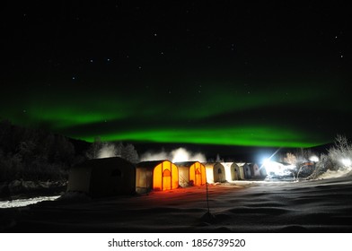 Alaskan winter mining camp under northern lights