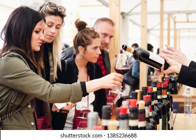 ALBA, ITALY - APRIL 25, 2019 â€“ Sommelier And Women Tasting Traditional Red Dolcetto Wines Of Piedmont At Vinum, Wine E Food Show Event Of Alba, (Italy) On April 25, 2019