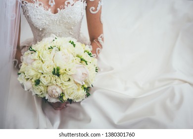 Albanian bride holding a bouquet of white and yellow flowers in her wedding dress - Shutterstock ID 1380301760