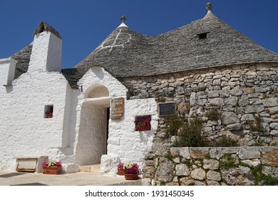 Alberobello, Apulia, Italy - June 28 2020: Trullo Siamese, two cones traditional Trulli house with white facade and made with stone, popular tourist destination