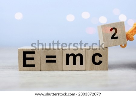 The Albert Einstein physics equation is E equals m c squared in a wooden block of dice. physics education concept