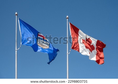 An Alberta and Canada flag waving.