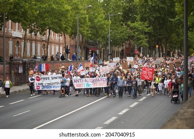 Albi, France - July 31, 2021 - A large procession of protesters demonstrating against compulsory vaccination, "sanitary pass" and health restrictions go down the street, on Lices Georges Pompidou