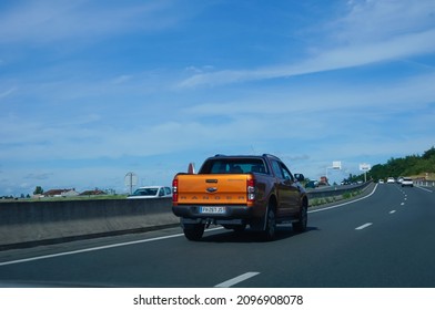 Albi, France - June. 2021 - Rear view on an orange Ranger driving on the RN88 freeway ; the Ranger is an all-terrain pick-up equipped with a dumpster at the back, produced by US car manufacturer Ford