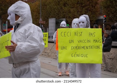 Albi, France - Nov. 2021 - Demonstrators At A Pro-freedom Protest, In Hospital White Coats, Wearing Masquerade Masks, Show Off Placards Which Denounce Covid-19 Vaccines As An Experimental Gene Therapy