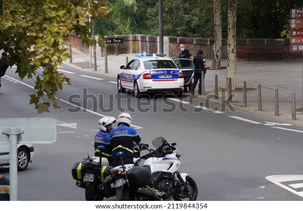 Albi, France - Sept. 2021 - Police officers, on\
foot, by car and by motorbike at a roadblock, control the traffic\
on the street during a demonstration against the health pass and\
Covid measures