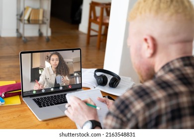 Albino african american businessman noting during video call with biracial female colleague. unaltered, business, wireless technology, working, teamwork and office concept. - Powered by Shutterstock