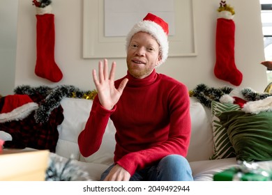 Albino african american man wearing santa hat making video call with christmas decorations. christmas, festivity and communication technology festivity and communication technology. - Powered by Shutterstock