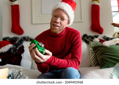 Albino african american man wearing santa hat making video call with christmas decorations. christmas, festivity and communication technology festivity and communication technology. - Powered by Shutterstock