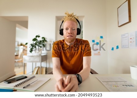 Albino african american man working from home making video call. remote working using technology at home.