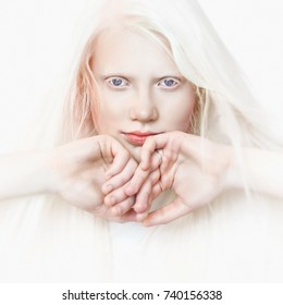 Albino girl with white skin, natural lips and white hair. Photo face on a light background. Portrait of the head. Blonde girl