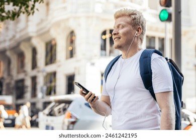 Albino man walking down the street using smartphone and listening to music with headphones - Powered by Shutterstock