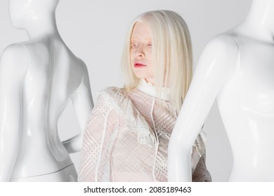 Albino Model In Blouse Standing Near Mannequins Isolated On White