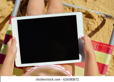 Albufeira, Portugal - 10 October, 2016: Child Holding In Hands Apple Ipad 2 Tablet Computer On Beach Outdoors Background. Vacation Relaxation Closeup Shot. Mobility E-reader, Smart Pad On Chair