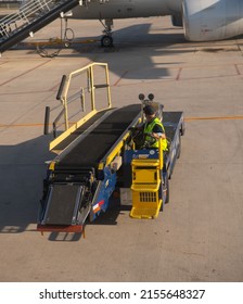 Albuquerque, New Mexico, U.S.A.- April 30, 2022; Male Airport Worker Driver Backs Up Empty Luggage Conveyer Loader On The Tarmac Of The Albuquerque International Airport In Albuquerque New Mexico 